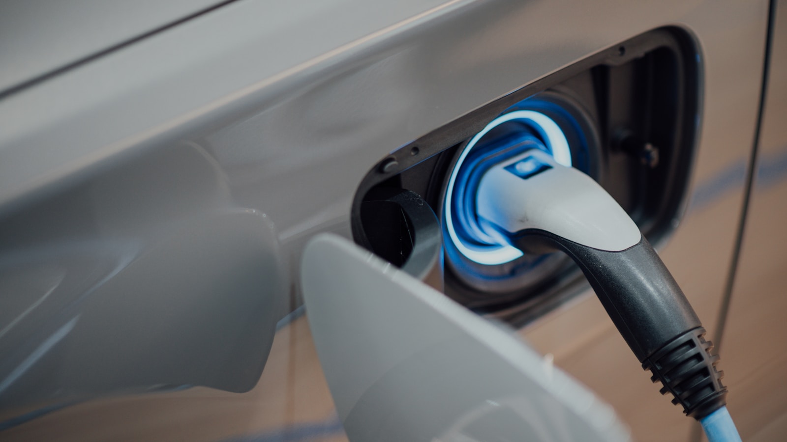 An EV charging cable plugged into the front of an electric vehicle - the install that pays in real, not the gold rush most electricians were sold.